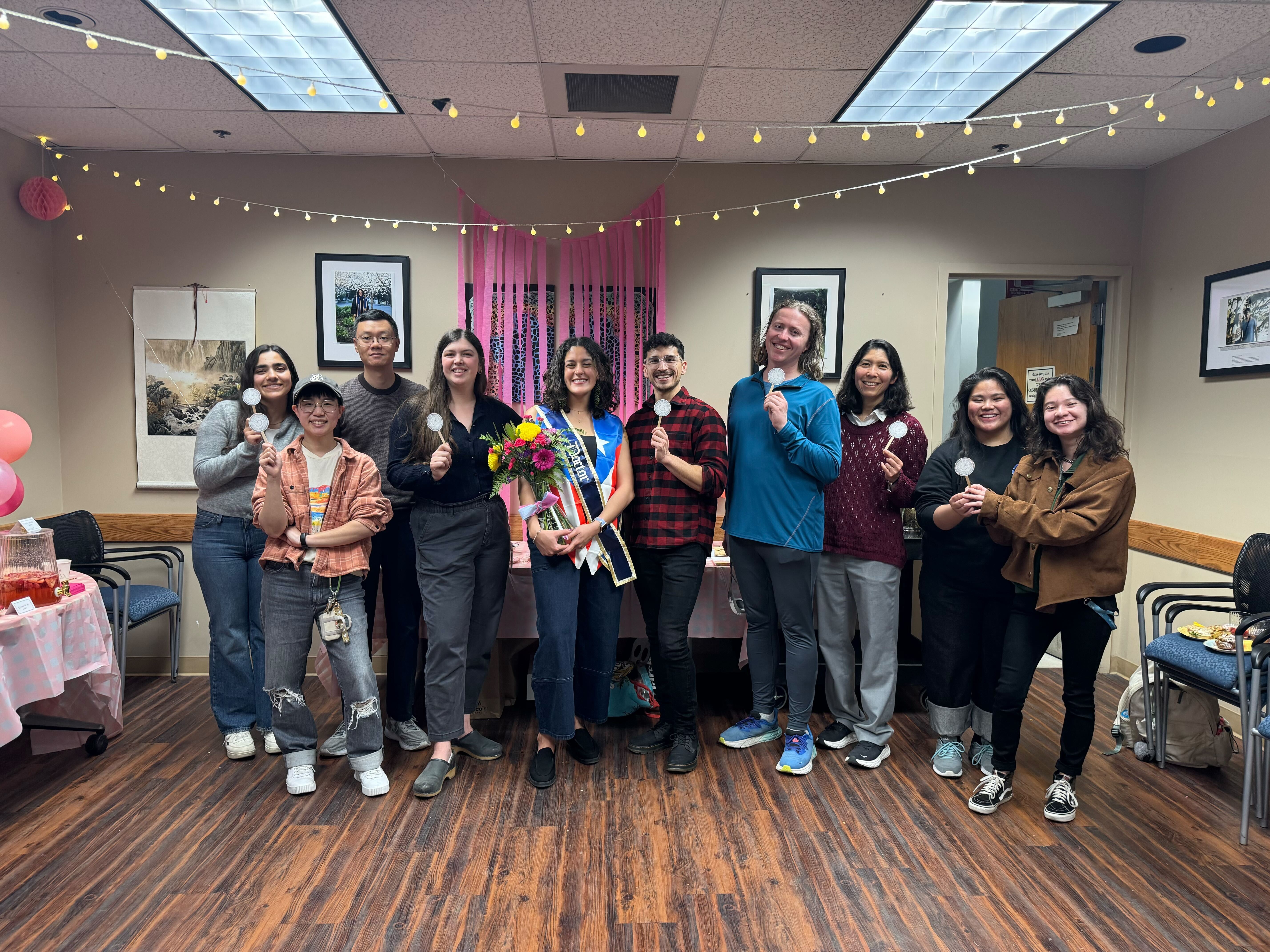 Individuals standing in a line holding small printouts of phylogenies.